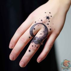 a woman's hand with a crescent and stars tattoo on it