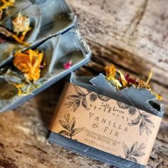 a bar of soap sitting on top of a wooden table next to some dried flowers