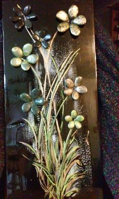 a vase filled with flowers sitting on top of a wooden table next to a wall