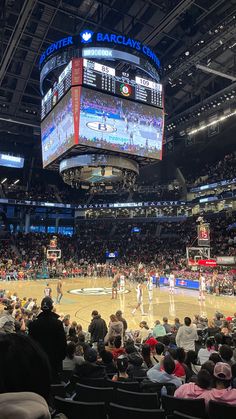 a basketball game is being played at the center of an arena with people sitting in chairs watching