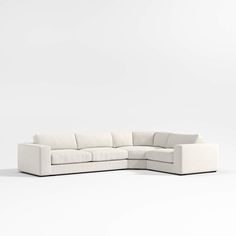 a white sectional couch sitting on top of a white floor