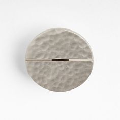 a round metal object sitting on top of a white surface