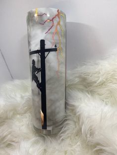 a tall glass vase with a cross on it sitting on a white furnishing