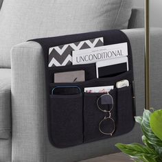 a gray couch with a black and white purse hanging from it's back pocket