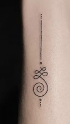 a black and white photo of a small tattoo on the arm, with an arrow in the middle