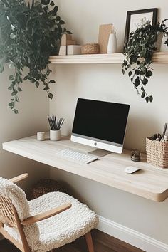 a white desk with a computer on it and some plants in the corner next to it