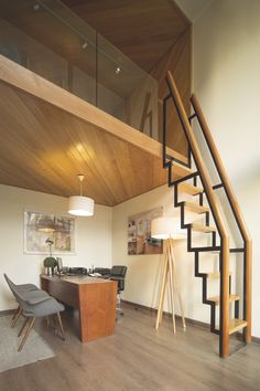 an open concept living room with stairs leading up to the second floor