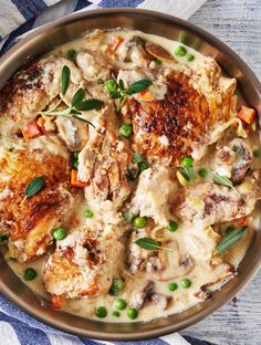 a pan filled with meat and vegetables covered in gravy on top of a table