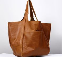 "Elegant Leather Large Carryall, Oversized leather bag, very large soft handbag, tan leather. Height: 39 cm / 15.3\" Height from top of handle to base: 68 cm / 26.8\" Handle drop: 26 cm / 10.2\" Width: 34 - 74 cm / 13.4\" - 29.1\" Depth: 28 cm / 11\" - Large, very roomy bag made of soft distressed leather. - Unlined - Inside two spacious section. - Top closure magnet for security. Add this gorgeous bag to your collection!! To return to my shop, simply click here: https://www.etsy.com/shop/Barbar Brown Leather Hobo Bag With Rolled Handles, Classic Leather-lined Hobo Tote Bag, Brown Textured Leather Shopping Bag, Eco-friendly Large Capacity Leather Shoulder Bag, Oversized Purse, Dark Tan Leather-lined Tote Bag, Tan Leather Bag, Cognac Shoulder Tote Bag With Gold-tone Hardware, Large Leather Bag