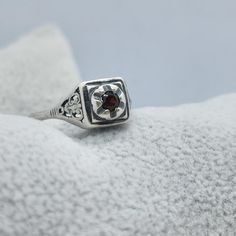 This vintage Joe Espisito ring is a stunning piece of jewelry that will make any occasion special. The ring is made of sterling silver and features a beautiful blood red garnet stone. The filigree design adds a touch of elegance to the ring, making it perfect for a formal event or a day at the beach. The ring is a size 5.25 and is signed by the artist. It is a unique piece that will make a great addition to any collection. Whether you are buying it as a gift or for yourself, this ring is sure to impress. Thank you for considering our merchandise! All items are described to the best of our knowledge. Vintage and antique pieces may show signs of wear consistent with their age.  Note there may be reflections, if any, from the camera or lights. Please look carefully at all the photos as they a Vintage Garnet Birthstone Promise Ring, Antique Garnet Promise Ring, Vintage Garnet Birthstone Rings, Vintage Garnet Promise Ring, Vintage Garnet Birthstone Ring For Anniversary, Vintage Red Hallmarked Signet Ring, Vintage Sterling Silver Jewelry For Anniversary, Collectible Garnet Ring Jewelry, Collectible Garnet Ring