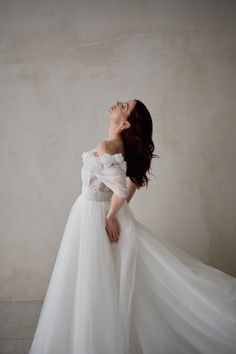 a woman in a white dress posing for the camera