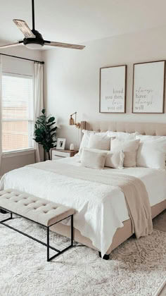 a bedroom with white bedding, pillows and two pictures on the wall above it