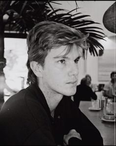 a black and white photo of a man sitting at a table