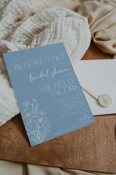 a blue and white wedding card on top of a bed