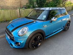 a small blue car parked on the street