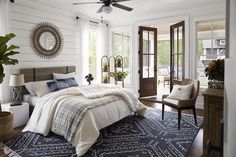 a bedroom with a bed, chair and rug in front of the door that leads to another room