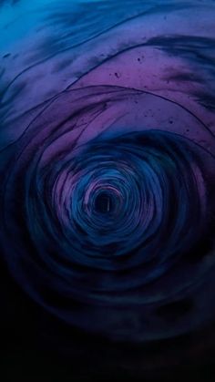 the inside of a blue and purple swirl with water swirling in it's center