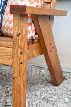 a wooden chair sitting on top of a gravel covered ground