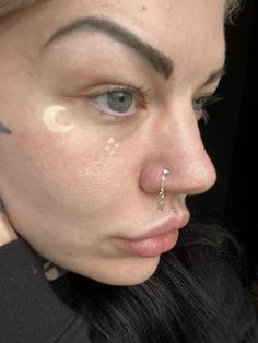 a woman with piercings on her nose looking at the camera