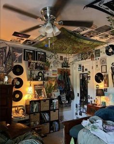 a bedroom with many pictures and records on the wall, ceiling fan and bed in foreground