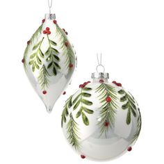 two white christmas ornaments with green leaves and red berries on the top, one is hanging from