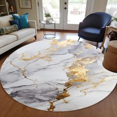 a living room with a white and gold marble rug on the floor next to a blue chair