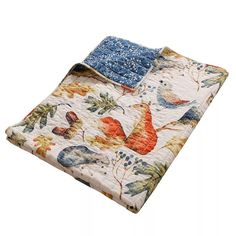 a quilted blanket with an orange and blue bird design on the front, sitting on top of a white surface