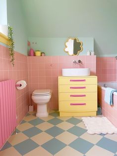 a bathroom with pink and blue walls, checkered flooring and a white toilet