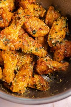 a bowl filled with chicken wings covered in seasoning