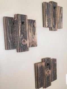 three pieces of wood are hanging on the wall with holes in them that look like they have been made from old boards