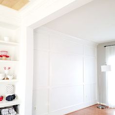 an empty room with white walls and wood flooring is pictured in this image, there are shelves on either side of the wall