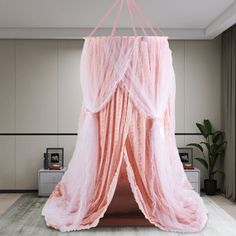 a pink canopy bed in a room