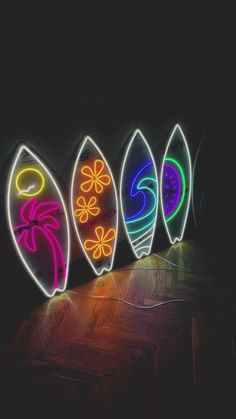 four surfboards are lit up in the dark