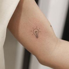 a small light bulb tattoo on the left arm and right arm, which is drawn in black ink