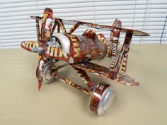 a toy airplane made out of cans on a table