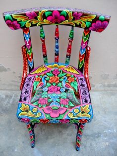 a colorfully decorated chair sitting on the ground