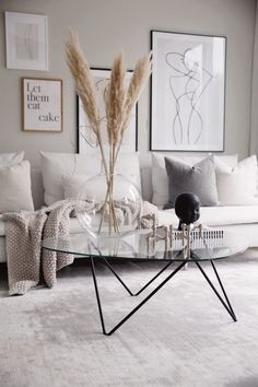 a living room with a couch, table and pictures on the wall