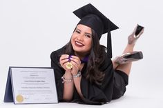 a woman is laying on the floor with her diploma and shoes in front of her