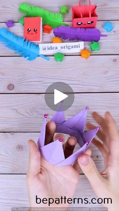 two hands are holding origami pieces in front of a wooden background with text that reads