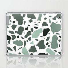 an animal print laptop case with green and white spots on the side, sitting on a table