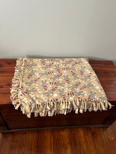 a wooden table topped with a blanket on top of it