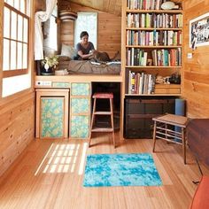 a man is sitting on the bed in his tiny cabin