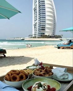 food on a tray at the beach with a buliding in the background