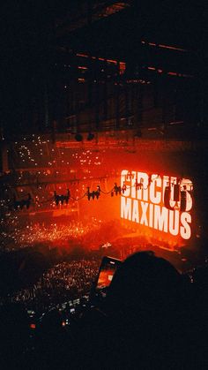 the words circus maximus lit up at night in front of an arena full of people