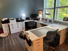 an office with two desks and several drawers