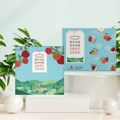 two greeting cards with apples on them sitting next to a potted plant and an egg