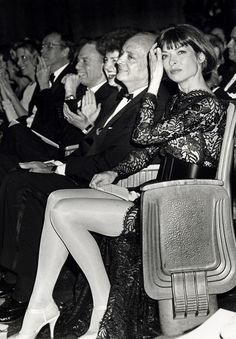 an old black and white photo of people sitting in chairs with their hands up to their ears