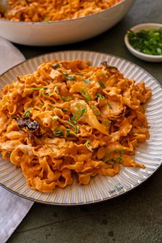 two plates with pasta and vegetables on them