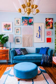 a living room filled with blue couches and pictures on the wall above them,