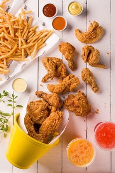 fried chicken, french fries and ketchup sit on a table next to condiments